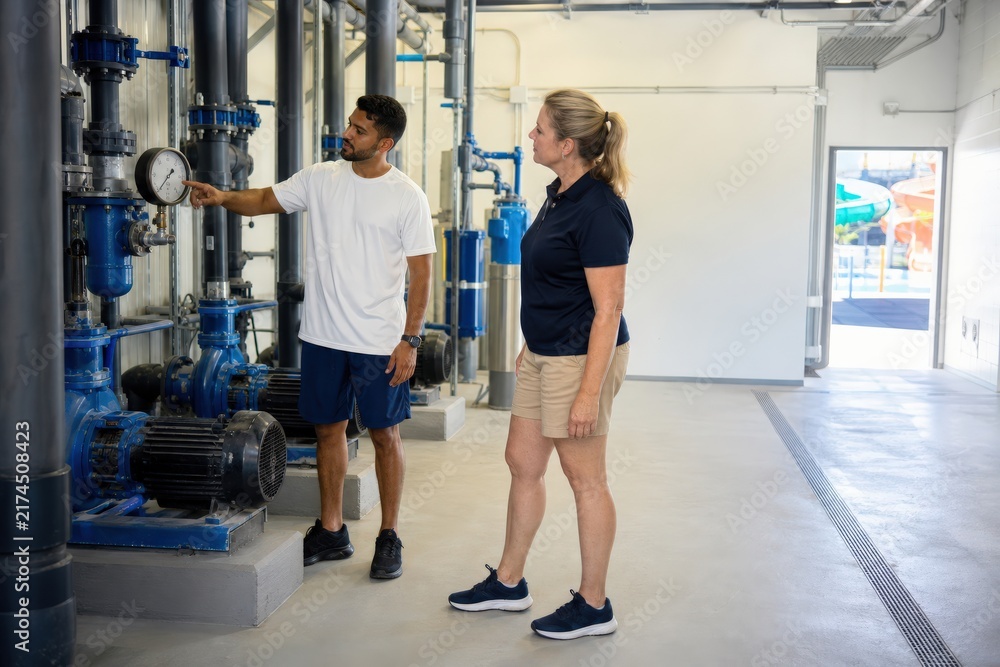 Fototapeta premium Public Pool Chemical Safety Cooperative Pump-room Inspection At A Waterpark Before Opening One Brazilian Aquatic Operator In His With A Build Points To An Analog Recirculation-flow Gauge