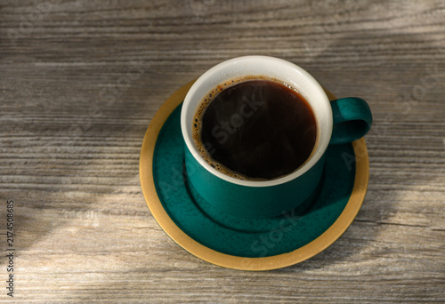 Konstfotografi Top-down view of a steaming cup of black coffee on a matching saucer and rustic