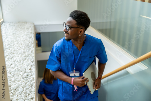Male medical professional smiling walking up stairs