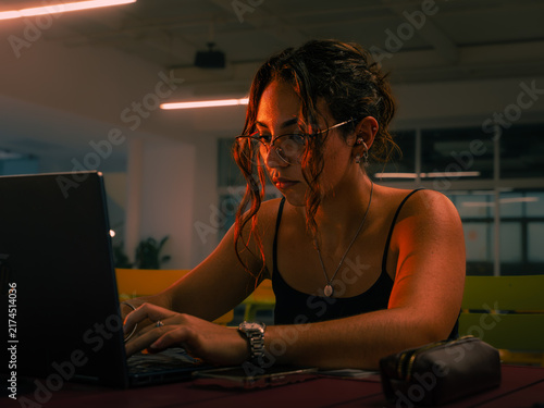 Foto Focused woman studying working late night with laptop