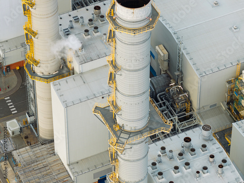 Quadro su tela Tall Smokestacks Rise Above the Industrial Power Plant Facility During a Bright