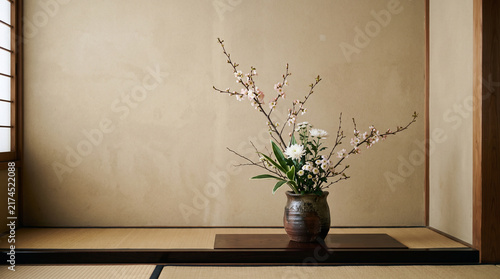 traditional japanese ikebana flower arrangement in ceramic vase on alcove tokonoma