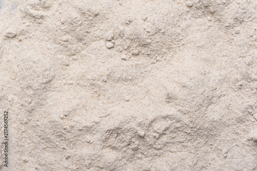 Close-up texture of organic rye flour, grey grain powder background, top view