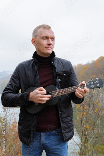 Fotografía Human interaction with wooden musical instrument ukulele guitar, emphasizing leisure creativity and personal expression