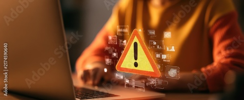 Person Using Laptop with Digital Warning Sign Overlay.