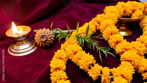 Close up vibrant marigold floral garland illuminated by candlelight on rich velvet backdrop