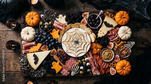 Overhead view of Halloween charcuterie snack board with spiderweb cheese