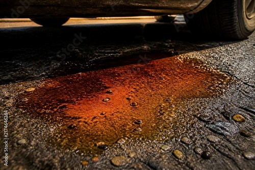 Rust colored puddle under parked car wheel