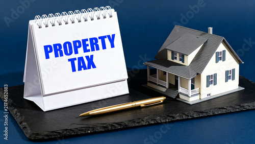 Property tax sign next to miniature house on black platform