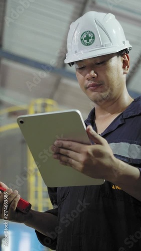Electrical engineer is communicating with team and use radio while working on digital tablet control electrical panel in industrial plant. System PLC industrial manufacturing. Factory industry 