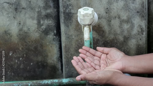 Person Holding Cupped Hands Under Water Tap Expecting Water - Water Scarcity, Crisis, Drought, and Hygiene Concept