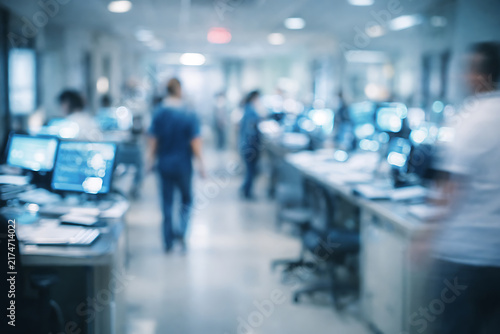 Blurred hospital staff working in a modern clinical ward with computers and monitors