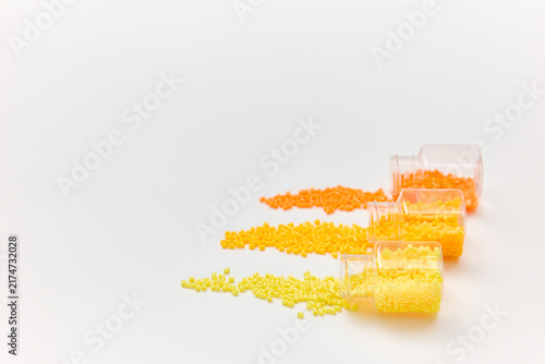 Assorted Yellow and Orange Beads Spilled from Small Containers