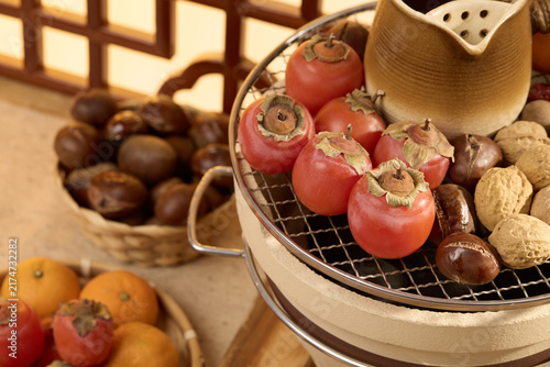 Autumn Fruits and Nuts on a Grill with Persimmons and Chestnuts