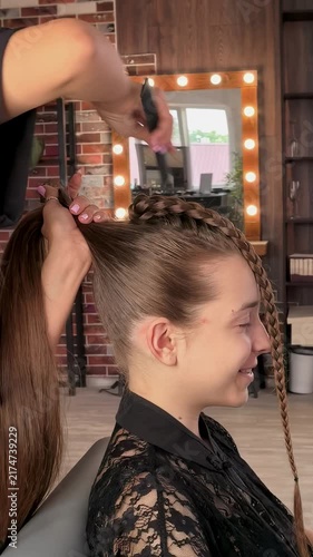 Teenage girl gets a braided ponytail hairstyle at a hair salon, professional hairstyling, youthful fashion and elegant beauty transformation.