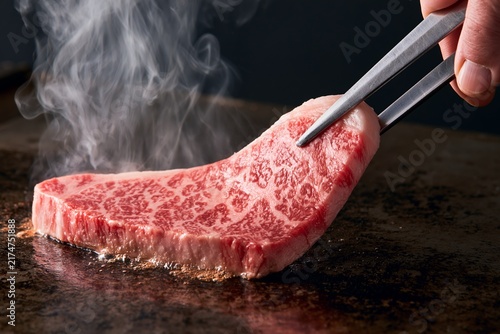 熱い鉄板で焼かれる和牛の高級ステーキ肉香ばしい香り