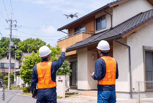 Naklejka ドローンを使用して戸建住宅の屋根を点検する作業員