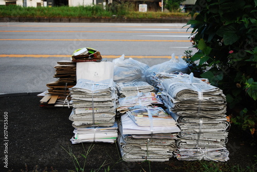 路上に積み上げられた資源ごみの古紙と新聞紙