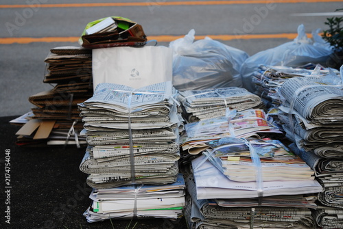 資源ごみとして路上にまとめられた古紙と雑誌の山
