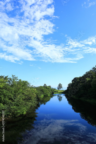 Blue Sky and Clouds Reflected on a Peaceful Pond Surrounded by Trees in Ojiya, Niigata, Japan