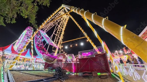 Vibrant Nighttime Pirate Ship Ride at a Busy Carnival Fair