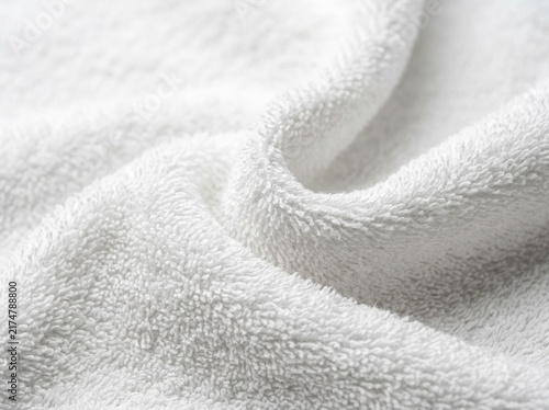 Soft white towel fabric texture background with clean cotton folds and waves.