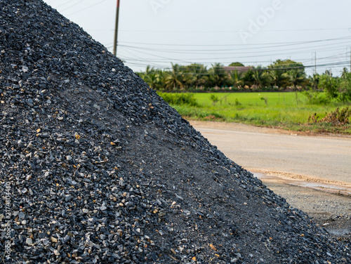 Obraz na płótnie Detailed view of substantial gravel mound set against lush green landscape backd
