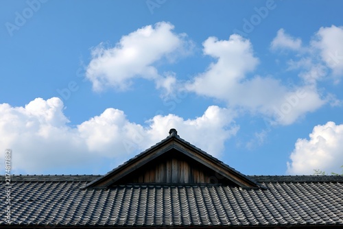 Obraz na płótnie 青空に浮かぶ白い雲と日本家屋の瓦屋根が美しい風景