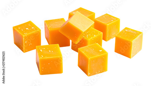 Close-up studio shot of golden-hued, cubed confections with light salt crystals on top, artfully arranged on a stark black backdrop