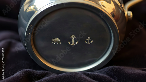 Antique silver cream jug with hallmark stamps on dark velvet, craftsmanship and heritage concept