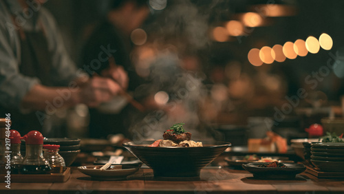 Fototapeta 暖かな照明に照らされたレストランのテーブルに並ぶ料理の空間背景