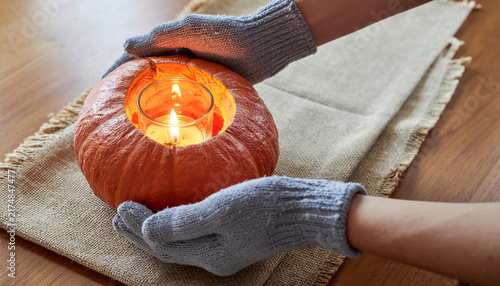 Holding Pumpkin Candlestick in Knitted Mittens on Burlap