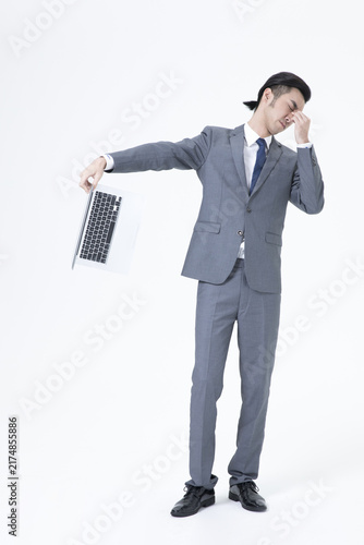 Quadro su tela Frustrated businessman holding laptop and pinching nose in stress