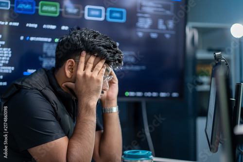 Fotografía Stressed programmer struggling with software development at computer desk in mod