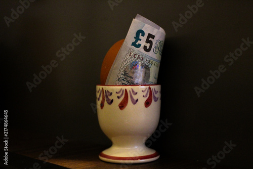 Fotografía An egg sits in an egg cup alongside a five-pound note to illustrate changes in f