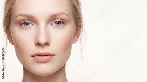 Close up portrait of a young woman with natural makeup looking at the camera lens with poses portrait against clean white background