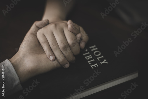 Foto Two people holding hands in prayer, sharing faith, hope, and support through Christian worship and devotion to God