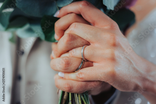 Foto Close up of bride and groom hands holding tightly with diamond wedding rings and