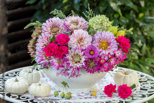 Blumenarrangement in Pink mit Dahlien, Rosen, Hortensienblüten, Schmuckkörbchen in alter Suppenterriene und weißen Kürbissen
