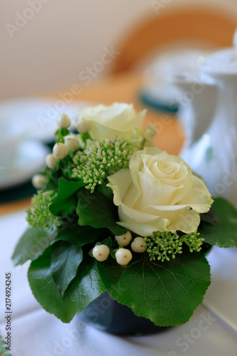 Ein dekorativer kleiner Rosenstrauß auf dem festlich gedeckten Tisch