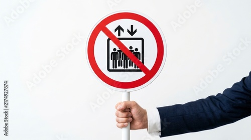 Hand holding a no elevator sign isolated on white background