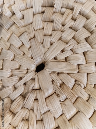 Center of a woven straw basket. Detailed macro shot of a circular handmade weaving pattern