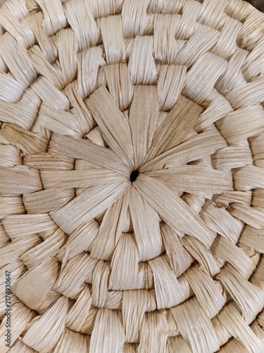 Center of a woven straw basket. Detailed macro shot of a circular handmade weaving pattern