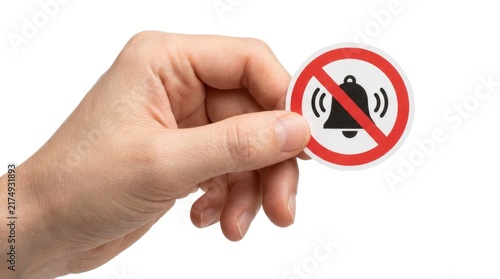 Hand holding a no bell symbol sticker isolated on white