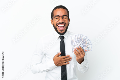 Young business latin man taking a lot of money isolated on white background smiling a lot