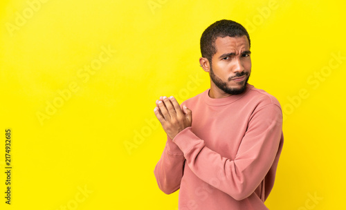 Foto Young latin man isolated on yellow background scheming something