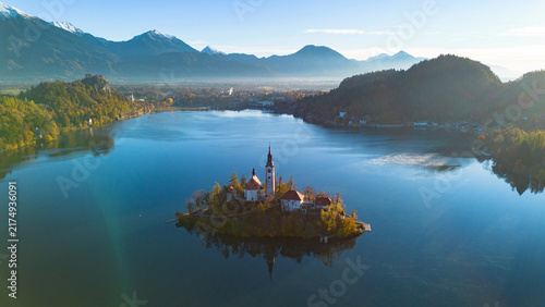 Obraz na plátně Aerial view of Bled Island and the Church of the Assumption rising above the calm waters of Lake Bled, surrounded by forested hills and the Julian Alps in Slovenia