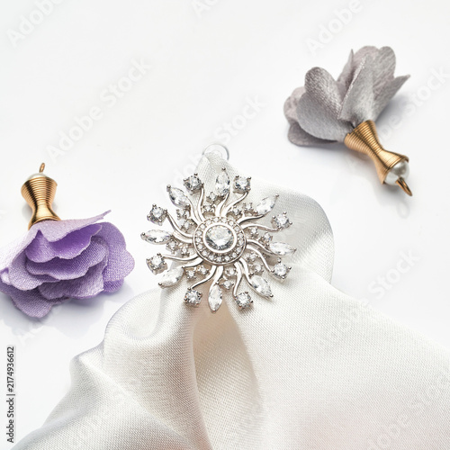 Photography Intricate Silver Pin with Sparkling Details Next to Delicate Fabric and Elegant