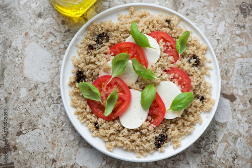 Canvastavla Plate of italian caprese with quinoa on a light-brown granite background, horizo