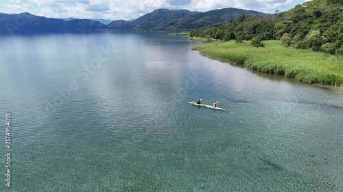 ドローン空撮　大自然に包まれた穏やかな湖の上のカヌーアクティビティ